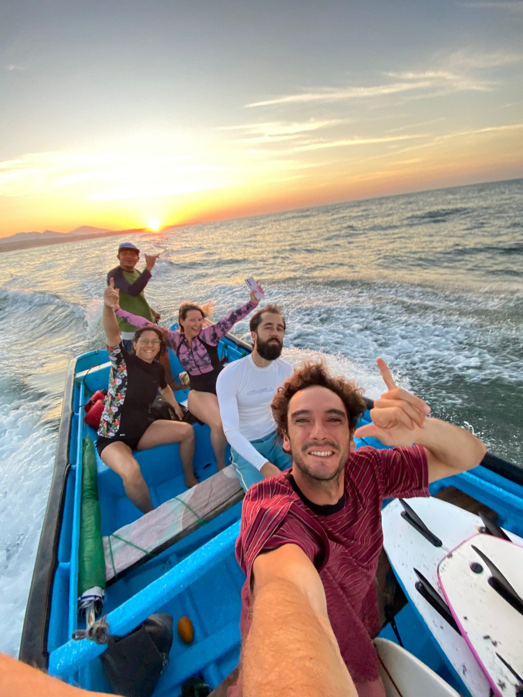 SurfXplore guests celebrating during a sunset boat trip in El Salvador