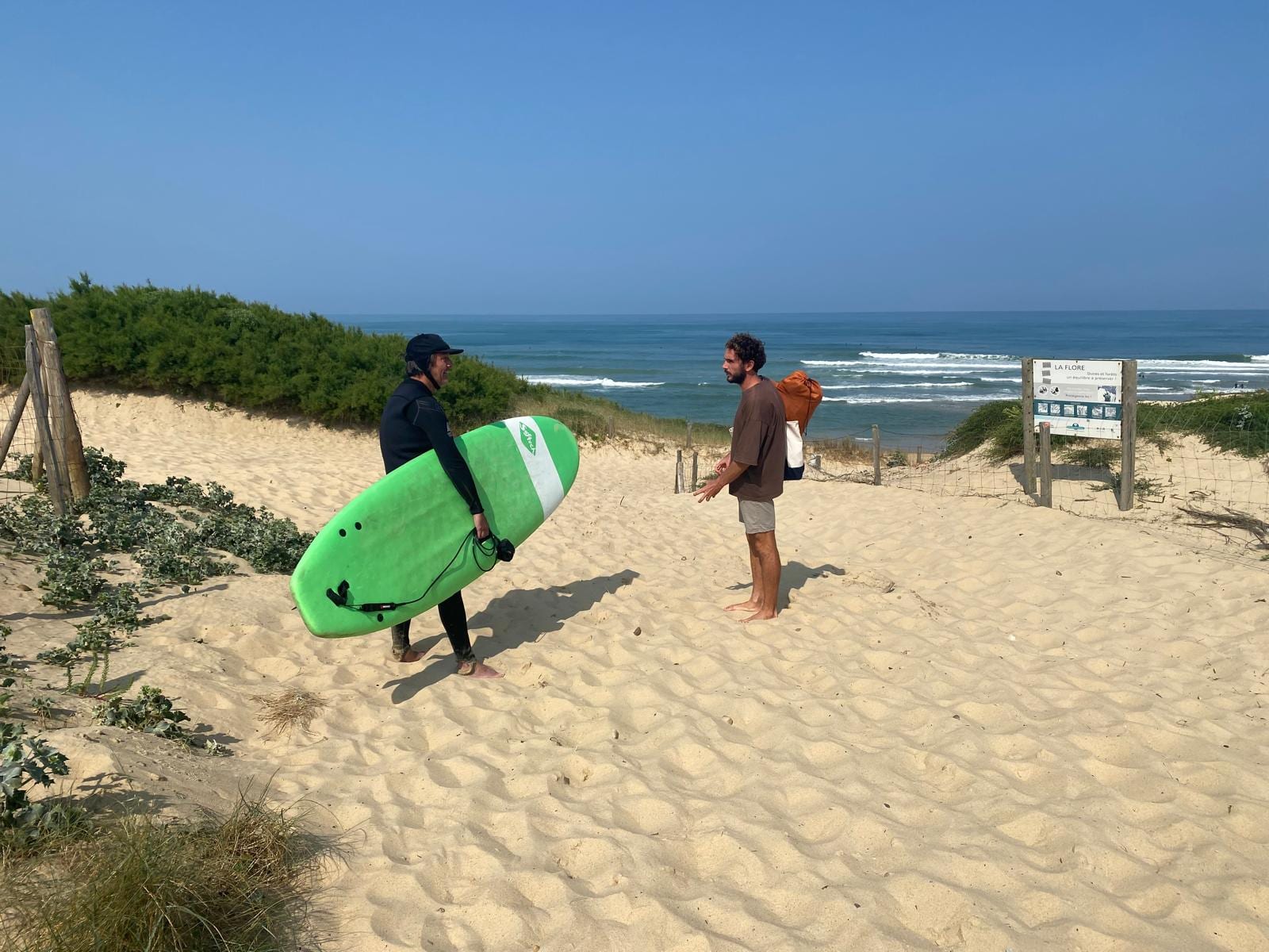 Surf coaching conversation on the dunes above a beach break in France