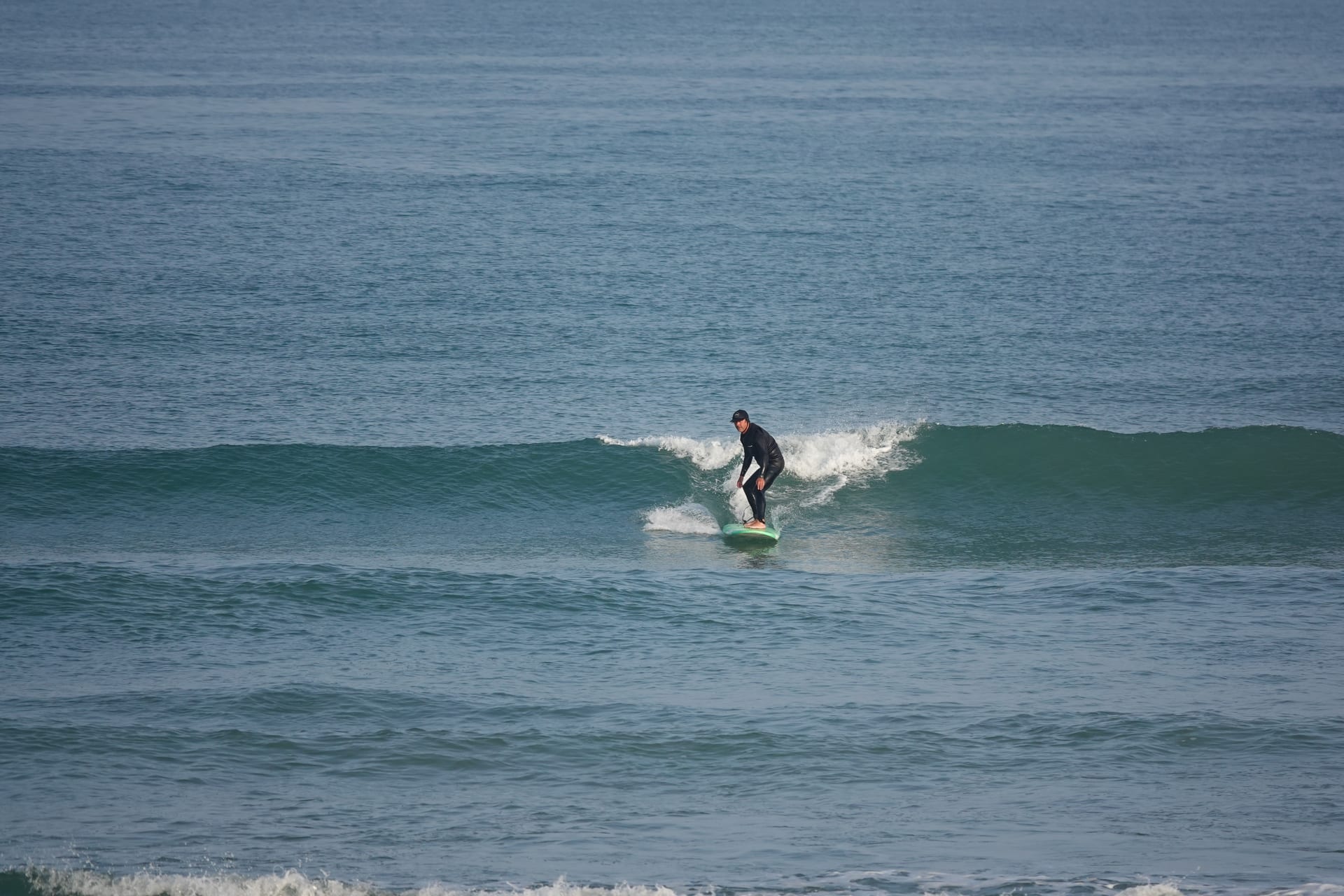 Surfer trimming across a clean wave on the French Atlantic coast