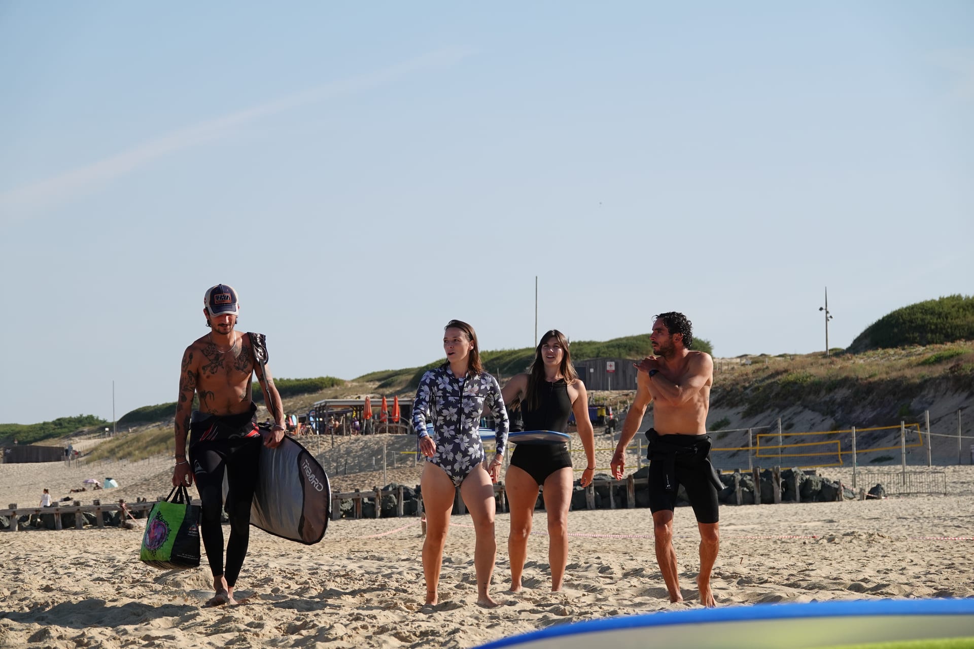 SurfXplore group walking across the sand after a surf session in France