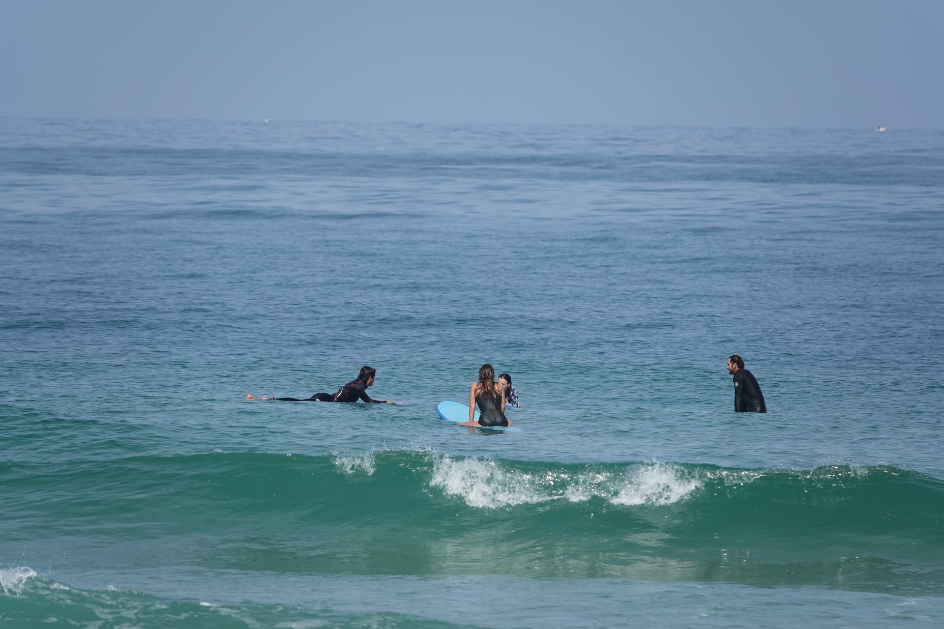Surf students sitting on boards in calm water during a France lesson