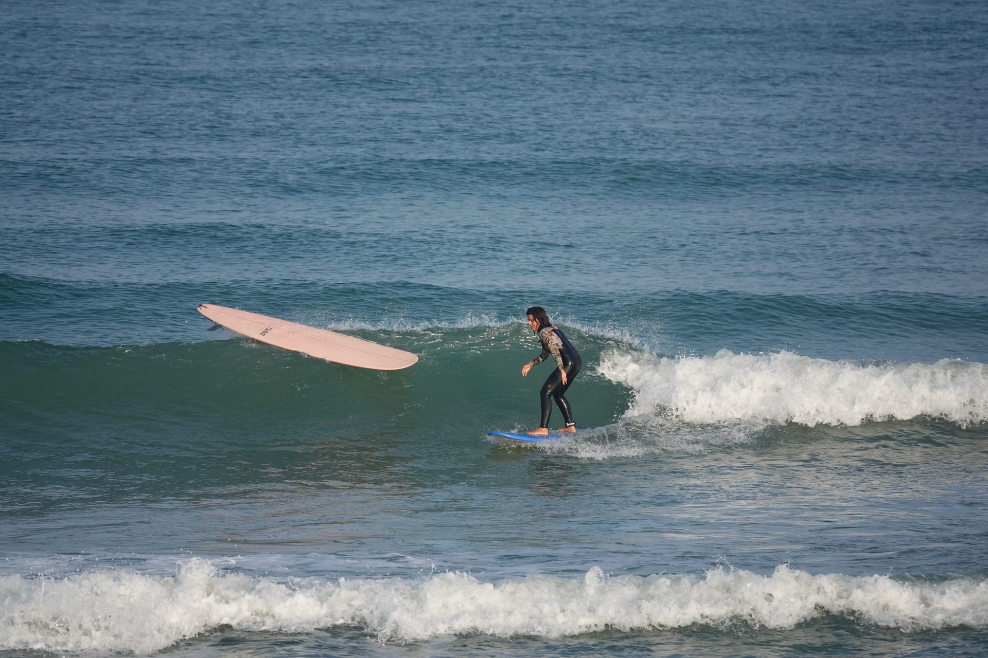 Surfer riding a small green wave during a lesson in France