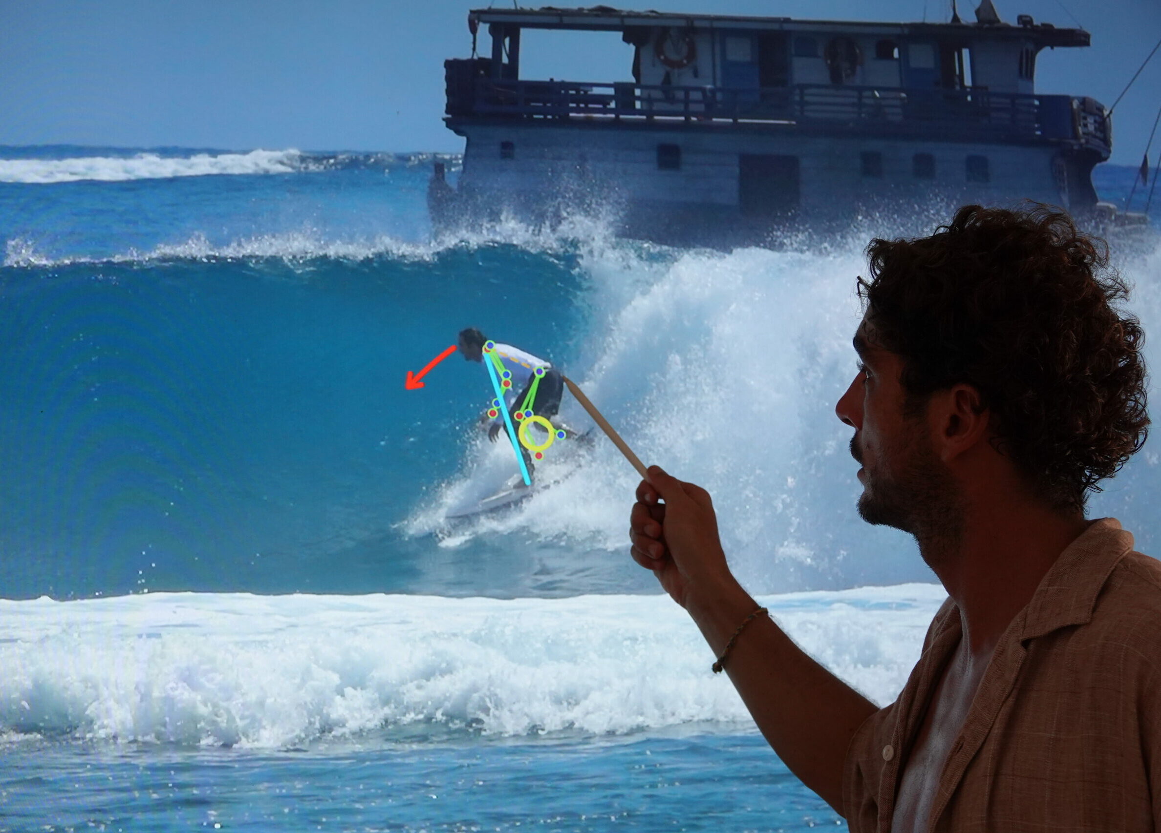 A SurfXplore coach reviewing technique with a surfer during a video analysis session on the beach.
